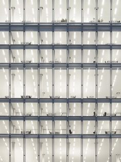 an office building with lots of windows and lights on the side of each window,