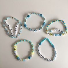 four bracelets with words and beads on them