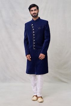 Midnight blue full sleeves layered sherwani crafted in velvet silk with Wildbloom motif thread embroidery using sequin highlights. Paired with an off white Aligadhi pant. - Aza Fashions Eid Velvet Fitted Bandhgala, Fitted Velvet Bandhgala For Eid, Velvet Bandhgala For Eid Festivities, Festive Velvet Fitted Sherwani, Blue Sherwani With Zari Work For Winter, Blue Sherwani With Naqshi Long Sleeve, Blue Sherwani With Naqshi For Festive Occasions, Blue Naqshi Sherwani For Festive Occasions, Blue Long Sleeve Sherwani With Naqshi Detailing