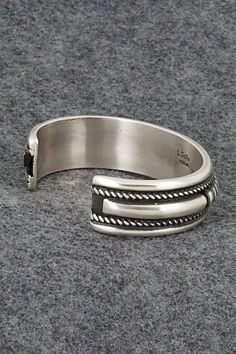 This sterling silver bracelet was made by Navajo silversmith Leander Tahe. The inside is signed L. Tahe and stamped sterling.Size: 5 5/8" (will fit up to a 7 1/8" wrist)Gap: 1 1/2"Width: 3/4"Free shipping on all orders! We ship with USPS and always include tracking. All orders ship within a day of payment.Returns are accepted up to 30 days after you receive your order. Just send us a message. Our shop offers cash back or store credit. The item must be returned in new condition. Artisan Sterling Silver Concho Cuff Bracelet, Adjustable Sterling Silver Concho Bracelets, Nickel-free Southwestern Sterling Silver Bracelet, Oxidized Sterling Silver Southwestern Bracelet, Oxidized Finish Southwestern Sterling Silver Bracelet, Sterling Silver Bracelet, Native American Jewelry, Free Jewelry, Sterling Silver Bracelets