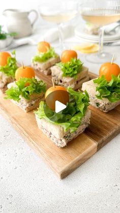 small sandwiches with lettuce and tomato on a wooden board