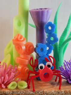 an ocean scene made out of pipe cleaners and seaweed with googly eyes