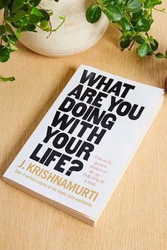 a book on what are you doing with your life? sitting next to a potted plant