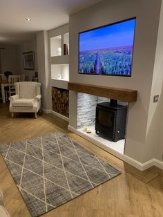 a flat screen tv mounted to the side of a wall next to a fire place