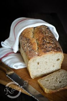 a loaf of bread sitting on top of a wooden cutting board next to a knife