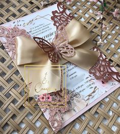 a close up of a wedding card on a table with flowers and ribbon tied to it