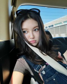 a young woman sitting in the back seat of a car with her hand on her hip