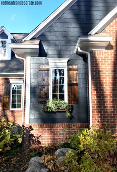 a brick house with white trim and shutters