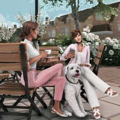 two women sitting at a table with a dog on the ground in front of them