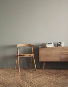 a wooden chair sitting next to a dresser on top of a hard wood floor in an empty room