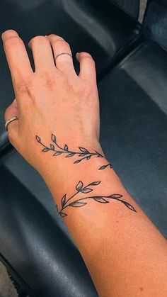 a woman's hand with a tattoo on her left wrist and an arrow in the middle