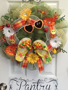 a wreath with sunglasses and flowers is hanging on the front door to say party please