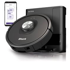 a smart phone is next to a robotic vacuum