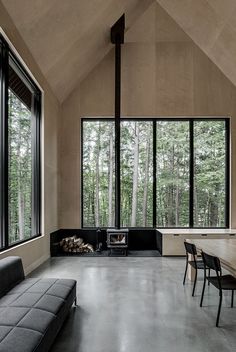 a living room filled with lots of windows next to a wooden table and couches