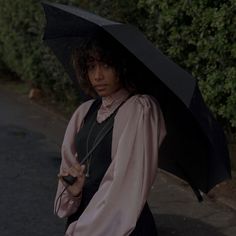 a woman holding an umbrella on the street