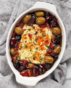 an oval casserole dish filled with olives and cheese