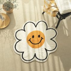 a rug with a smiley face drawn on it in the shape of a daisy flower