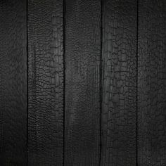 an image of black wood textured with dark paint or embossing on it