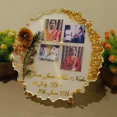 a personalized photo frame with flowers and pine cones on the table next to potted plants