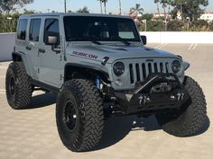 a gray jeep parked in a parking lot