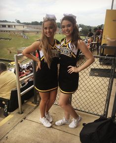 two cheerleaders posing for a photo at a baseball game