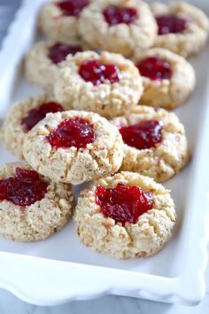 cookies with jam are on a white tray