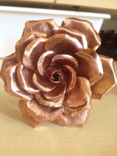 a metal flower sitting on top of a wooden table