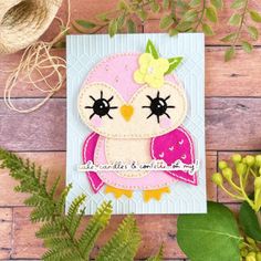 a card with an owl on it next to some plants and yarn, along with twine spools