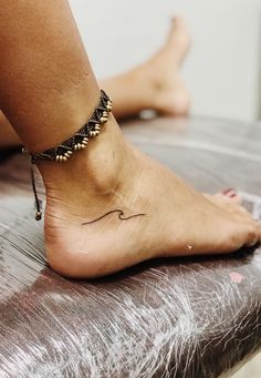 a woman's foot with a small tattoo on the side of her left ankle