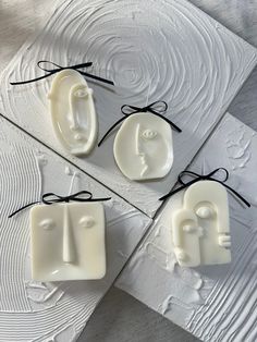 three soaps made to look like faces tied with string