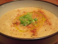 a bowl filled with soup on top of a wooden table