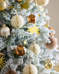 a white christmas tree with gold and silver ornaments