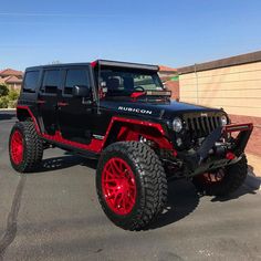 a black and red jeep parked in a parking lot