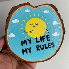 a piece of wood that says, my life my rules on it with a sun and clouds painted on it