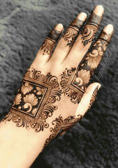 a woman's hand with henna tattoos on it