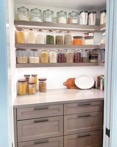 Appreciate an illuminated pantry that uses under-shelf lighting to brighten up the space. The floating wood shelves match the shaker cabinets installed on the lower walls. Display jars and canisters filled with dried goods along the shelves...   Image: hunterdonhomelife