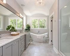 a bathroom with a tub, sink and large mirror