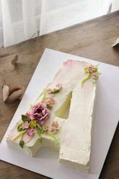 a white cake with flowers on it sitting on a table