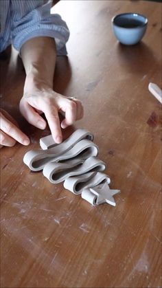 a person reaching for scissors on top of a wooden table