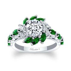 an engagement ring with green leaves and diamonds on the band, set in 18k white gold