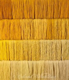 an array of yellow and orange yarns are arranged in rows on top of each other