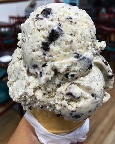 an ice cream cone filled with chocolate chip cookies and oreo chips in a restaurant