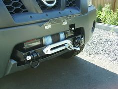 the front end of a truck with a winch on it's bumper and two springs