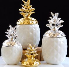 three white vases with gold pineapple decorations