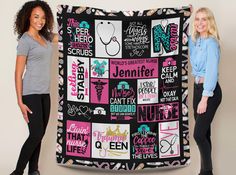 two women standing next to each other holding up a black blanket with pink and blue designs on it