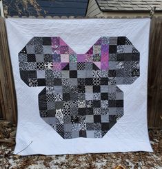 a mickey mouse quilt hanging on a fence