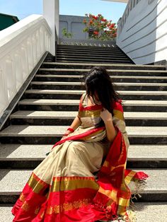 a woman is sitting on the steps wearing a sari