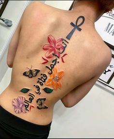 the back of a woman's body with flowers and butterflies on it