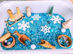 a bathtub filled with toys and snowflakes on top of blue flakes