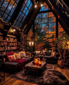 a living room filled with lots of furniture under a skylight in the middle of a forest